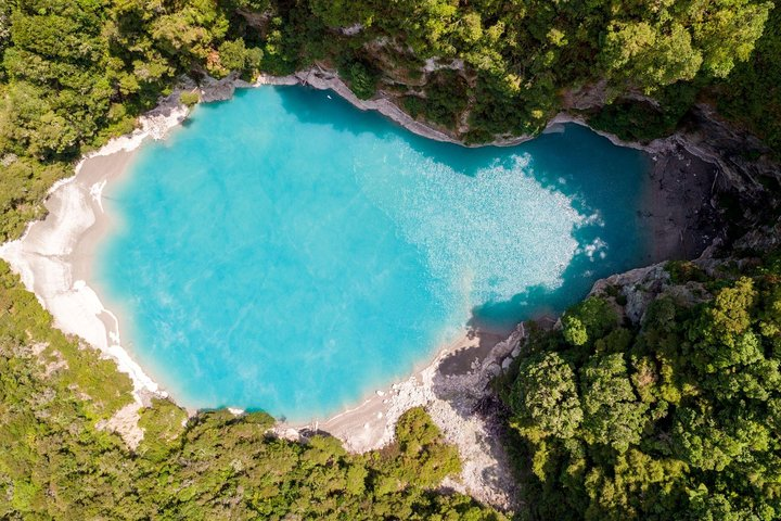 Immerse yourself in the stunning beauty of Waimangu’s turquoise waters surrounded by lush greenery. Experience unique geothermal features and serene landscapes on your self-guided hiking adventure.